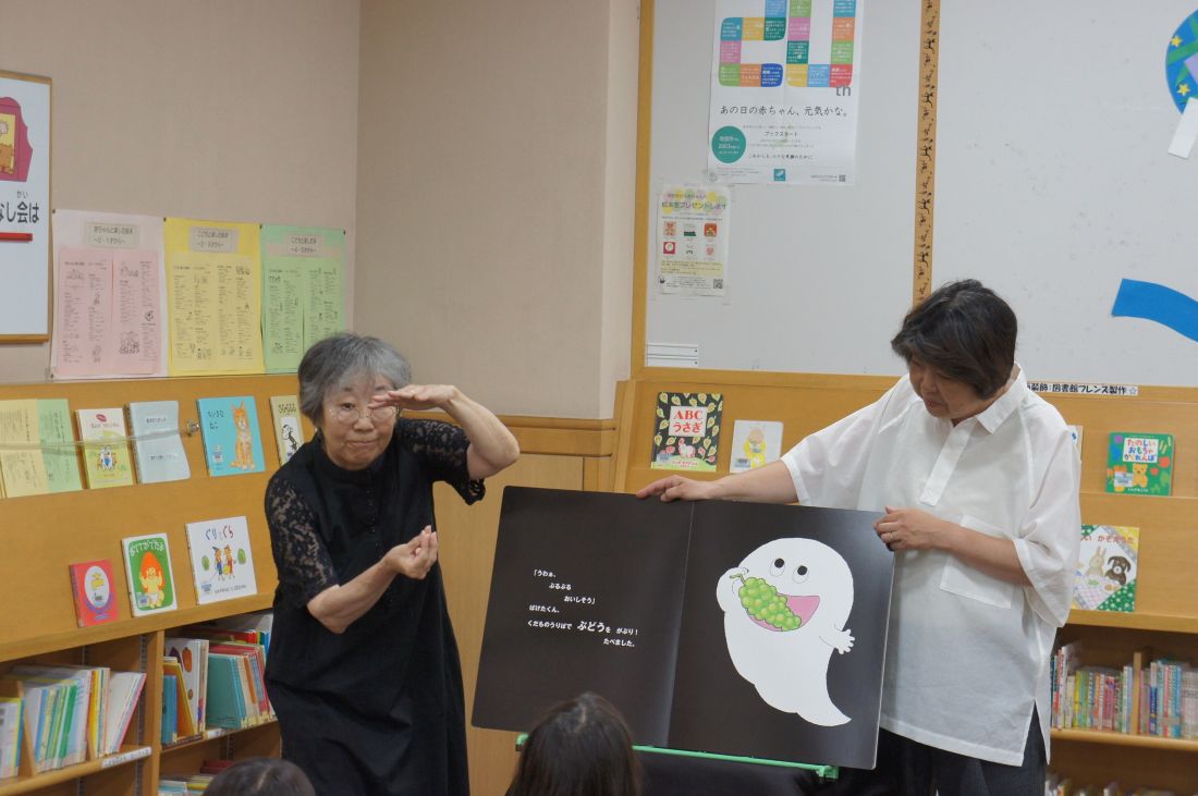 『』『ばけばけばけばけばけたくん　おみせの巻』の読み聞かせの様子。