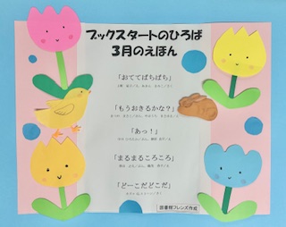 「ブックスタートのひろば」で3月に読む絵本を紹介したポスター。ピンクや黄色の花や、絵本のキャラクターの飾りつけがされています。