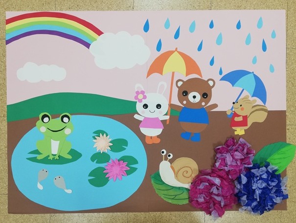 画用紙で作った空に雨が降り、虹がかかっている。池にはかえるとおたまじゃくしがいる。