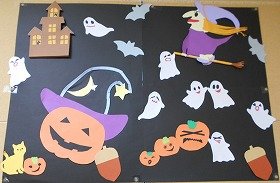 写真2　黒色の台紙の上に、画用紙でつくったおばけや魔女などがハロウィンを楽しんでいる。