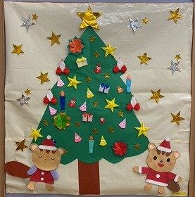 飾り付けられたクリスマスツリーの下にりすが2匹いる。