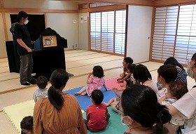 紙芝居「こねこのしろちゃん」を聞く子供たち。