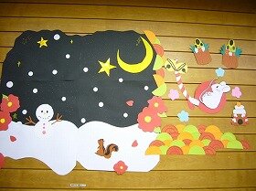 画用紙や折り紙で作った雪だるまとりすと大きな鈴を鳴らしているねずみの装飾。