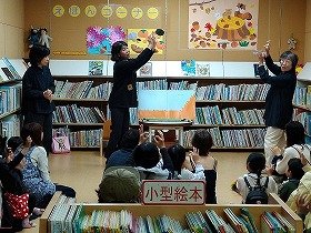 写真2：手話での読み聞かせで、参加者も一緒に手話をしている様子