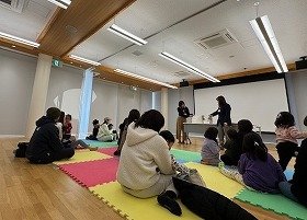 写真2　さわる絵本「くっついた」の読み聞かせを参加者が聞いている様子。