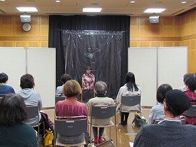 吹田おはなしの会の女性の方一人が、朗読をしている様子。