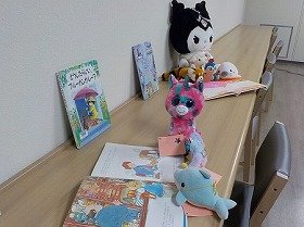 ぬいぐるみが絵本を読んでいる様子。