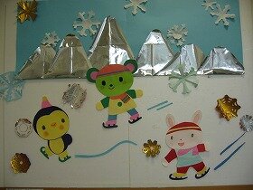 切り紙による壁面装飾です。ペンギンとクマとウサギの子どもがスケートをしています。遠くには山々が見え