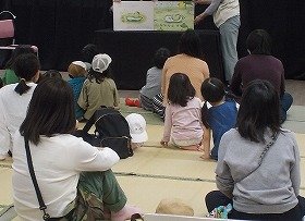 写真1　大型絵本『そらまめくんのベッド』の読み聞かせを聞いている参加者
