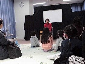 写真　おはなしをする人とお話を聞く親子たちの写真。