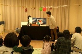 大きな絵本「まどから★おくりもの」を読んでいる写真