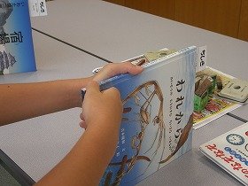 絵本の背表紙に場所を示すラベルを貼っている様子