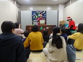 写真1：紙芝居『わすれんぼうのサンタさん』を見ている様子。