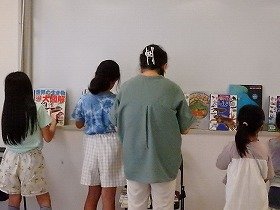 写真1　講師の先生と図鑑を選ぶ様子。