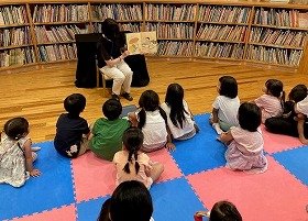 写真1）かわいいおばけ「とうふこぞう」が登場する絵本の読み聞かせの様子