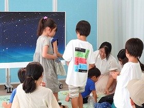 星空におりがみを貼る子供たちの様子。