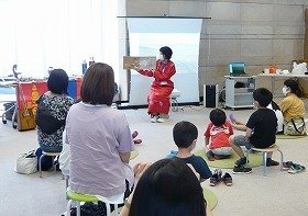 山田駅前図書館の職員が子供たちに向けて絵本『トヤのひっこし』を読んでいる様子。