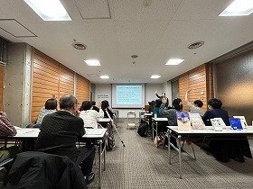 写真　講師の質問に対して挙手をして回答する参加者たち