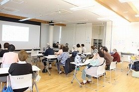 写真：健康医療情報講座「あなたの知らない肺がんのお話」で前方のスクリーンを見ながら講師のお話を聞いている参加者の様子。