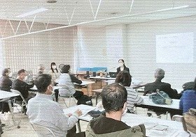 中央に講師の池田さん、熱心に話を聞く参加者の様子。