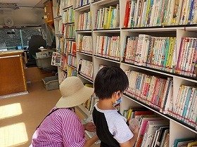 車内で本を選ぶ親子の写真