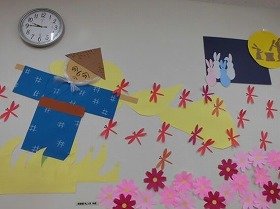 写真1　かかしとトンボ。足元にはコスモス。