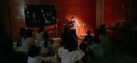 写真　演者が怖い話を朗読している様子。