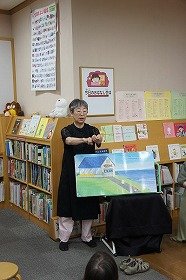写真　『ノラネコぐんだん　おすしやさん』の読み聞かせの様子。