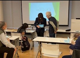 写真1：健康医療情報講座「パスファインダーの使い方」で、講師がタブレット端末を使って、参加者にパスファインダーの使い方を説明している様子。