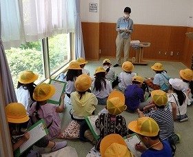 写真1　多目的室で図書館の使い方の説明を受ける子供たち。
