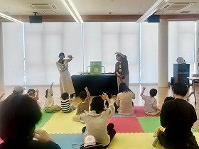 写真2：手あそび「さよならあんころもち」であんころ餅を作ろうと手を大きく動かす子供たち