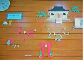 写真1　神社の前で羽根つき大会をしている蛇の装飾
