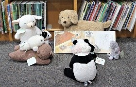 写真3　夜の図書館で、ぬいぐるみたちが、絵本の読み聞かせをしています。