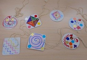 写真　参加者が作ったびゅんびゅんごまの写真です。うずまきや波線などの模様が描かれています。