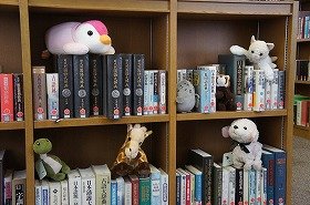 写真3　夜の図書館で、ぬいぐるみたちが調べ物をしています。