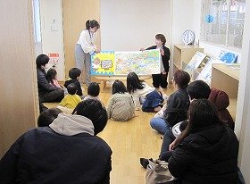 写真2　おはなしのへやで『じしんだ！』の絵本を読んでいる様子。