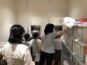 返却ポスト室を見学している様子。