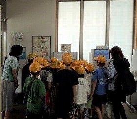 写真2　自動貸出機や図書除菌機を見る子供たち。