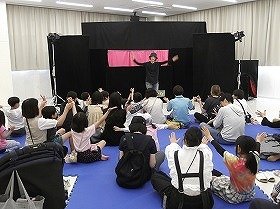 写真1　手遊び「トマトとトマト」みんなで声に合わせて手をひろげている様子。