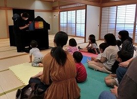 紙芝居「ひもかとおもったら」を聞く子供たち。