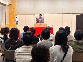 写真1　上方落語で使われる道具について説明する桂團治郎さんの写真です。