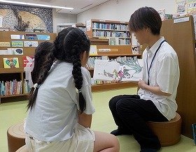 写真1　実習生が子供たちに読み聞かせをしている様子。