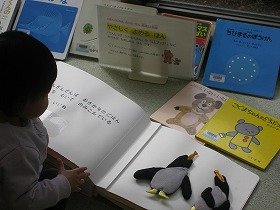 写真　読み聞かせが終わった後、並べられた点字付きの絵本をさわって楽しむ参加者。
