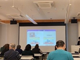写真2：健康医療情報講座「消化器内視鏡検査・治療最前線」で前方のスクリーンや配付資料を見ながら講師の説明を聞いている参加者の様子。