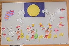 画像　野原のおつきみの風景。満月の夜空。飛び跳ねるウサギたち。赤とんぼ。すすき。弦楽器を弾く虫たち。9月の壁面装飾です。