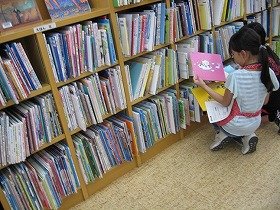 写真1　返却された本を元の棚に戻している様子