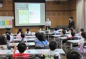 講師が数学博物館の様子をスライドで説明しているところ