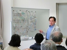 写真地図で場所を示しながら説明する講師。