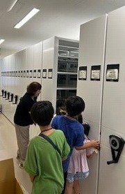 写真3　書庫の本棚を動かしてみているところ