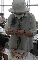 写真2　講師が新聞のちぎりかたを指導している様子